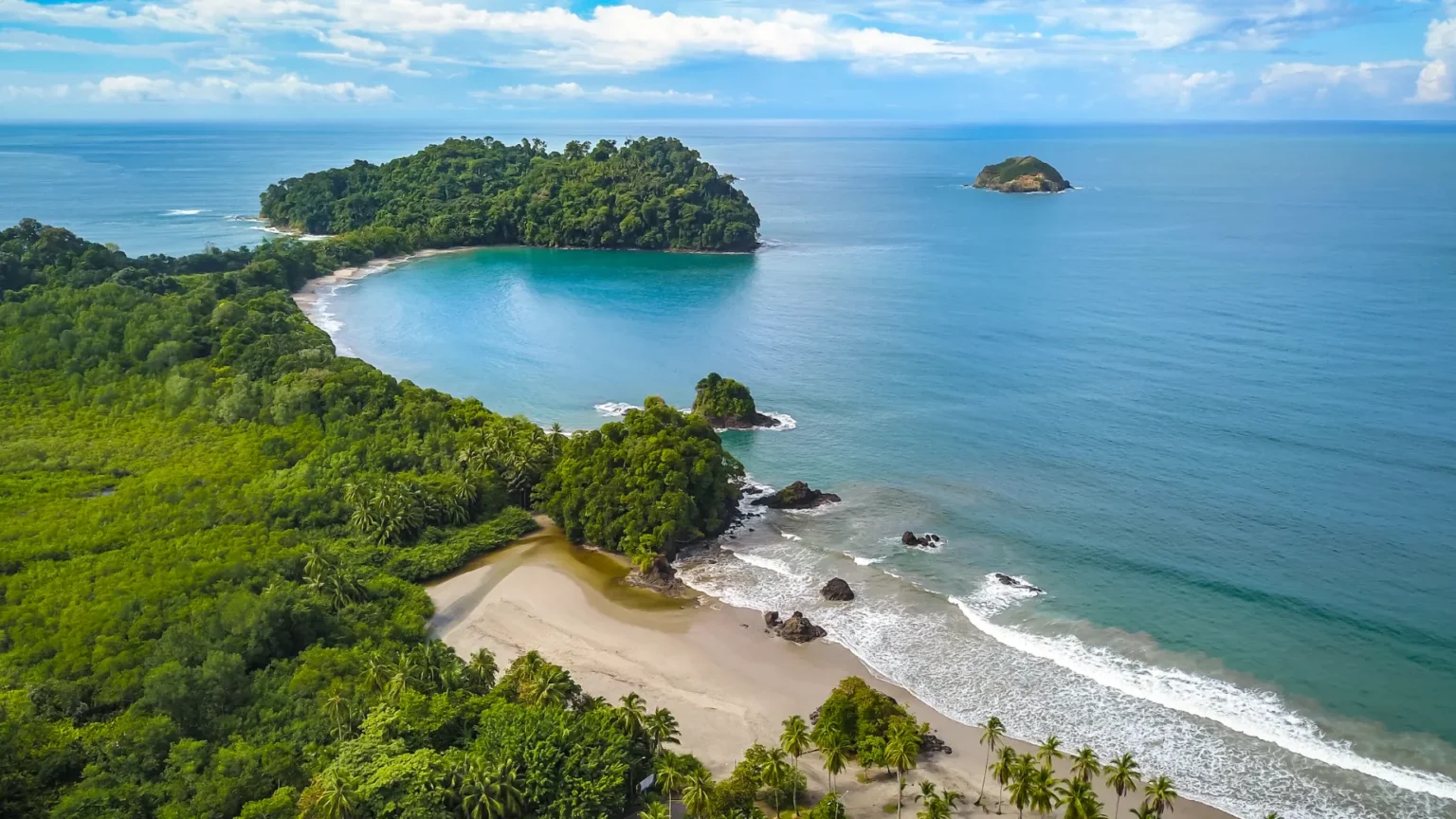 Parc national Manuel Antonio vue du ciel par un drone avec forêt, palmier et eaux turquoises.