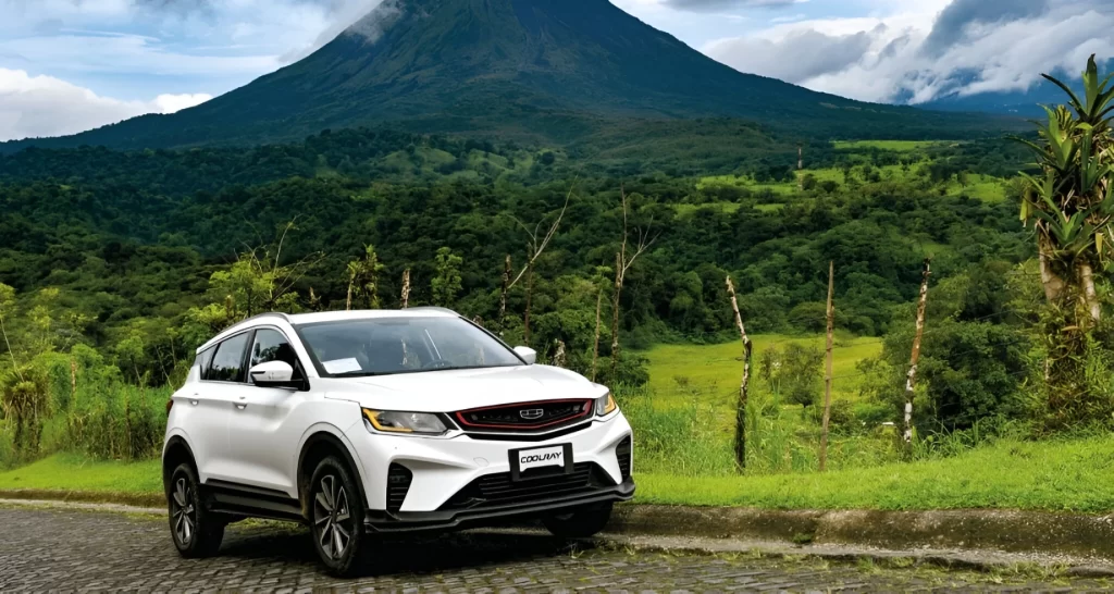 Geely CoolRay 4x2 blanc photographié devant le volcan Arenal, parfait pour explorer les paysages naturels du Costa Rica en liberté et confort