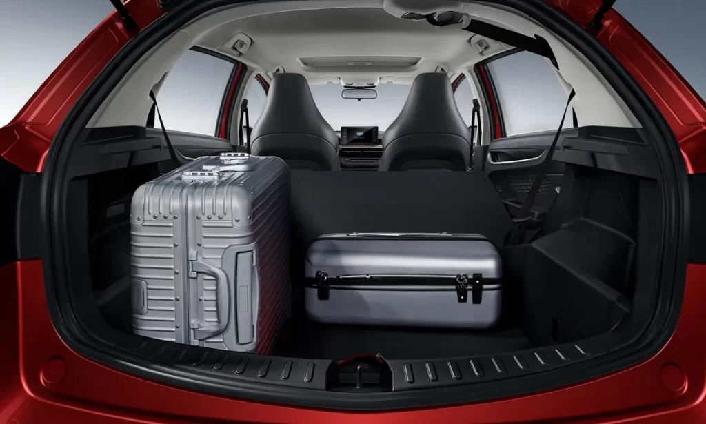 Coffre du Geely GX3 4x2 avec deux valises, illustrant la capacité de chargement pour un autotour au Costa Rica