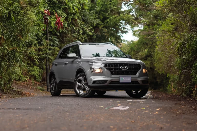 SUV Hyundai Venue sur une petite route bordée de végétation au Costa Rica, idéal pour circuler facilement dans les zones rurales ou les villes