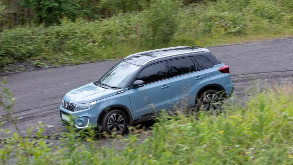 Suzuki Vitara 4x4 roulant sur une piste en gravier au Costa Rica, parfait pour affronter les routes secondaires en toute sécurité