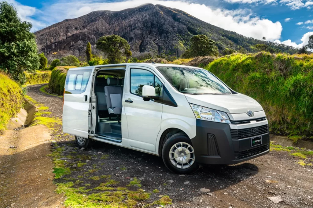 Toyota Hiace avec porte latérale ouverte sur une piste au Costa Rica, prêt à embarquer les passagers