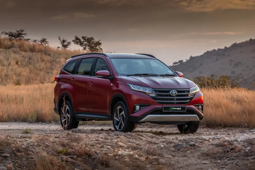 Toyota Rush rouge sur une piste au Costa Rica au coucher du soleil, parfait pour les familles nombreuses